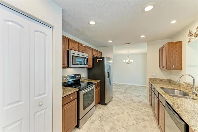 a kitchen with stainless steel appliances granite countertop a sink stove and refrigerator