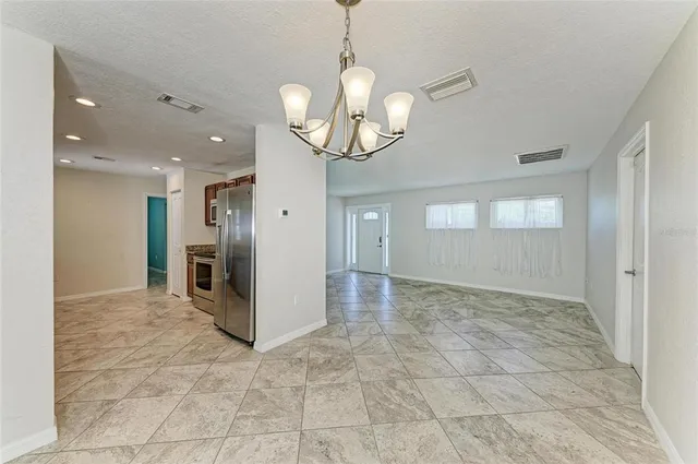 a view of a hallway with wooden floor and a kitchen