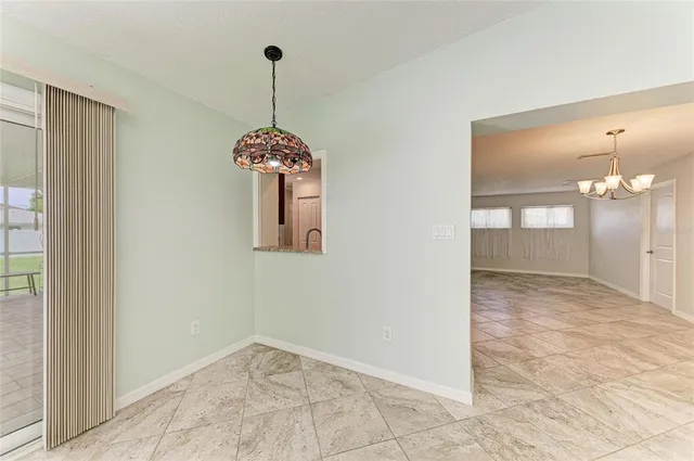 a view of a hallway with a chandelier fan and windows