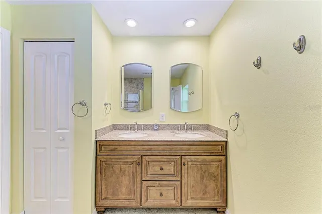a bathroom with a granite countertop sink a large mirror and a shower