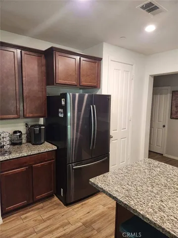 a kitchen with stainless steel appliances granite countertop refrigerator sink and cabinets