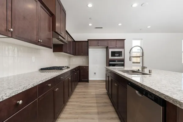 a kitchen with granite countertop stainless steel appliances and wooden cabinets
