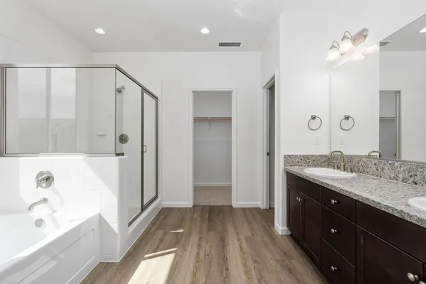 a bathroom with a granite countertop sink a toilet a large mirror a bathtub and shower