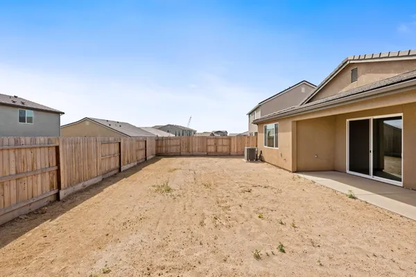 a backyard of a house with wooden fence
