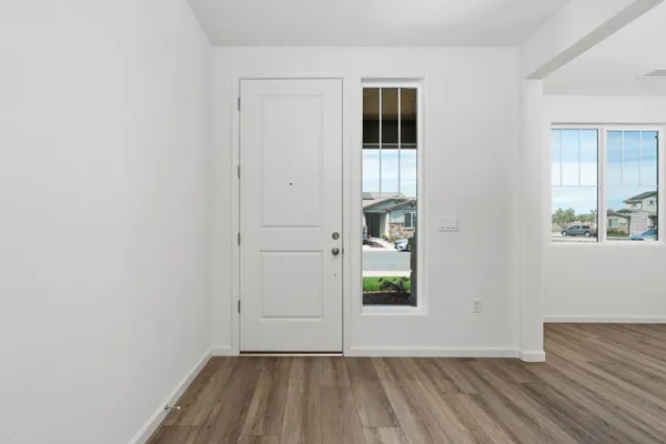 a view of hallway with window and wooden floor