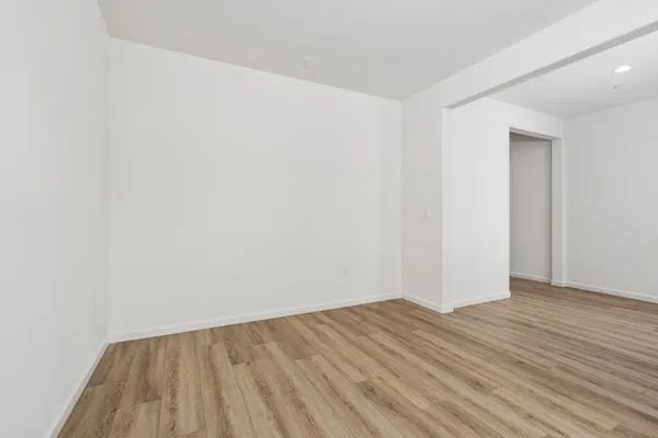a view of an empty room with wooden floor