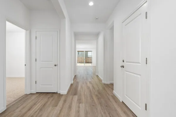 a view of a hallway with wooden floor and closet