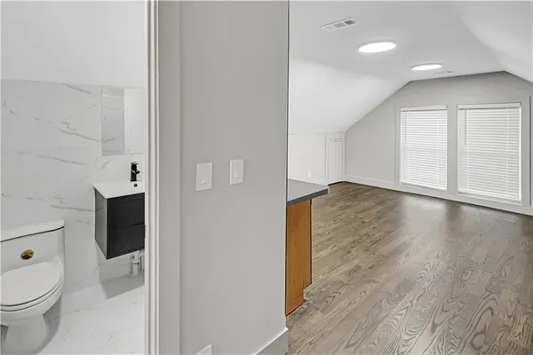 a view of bathroom with a toilet a sink and a mirror
