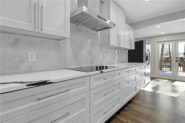 a kitchen with granite countertop white cabinets and white appliances