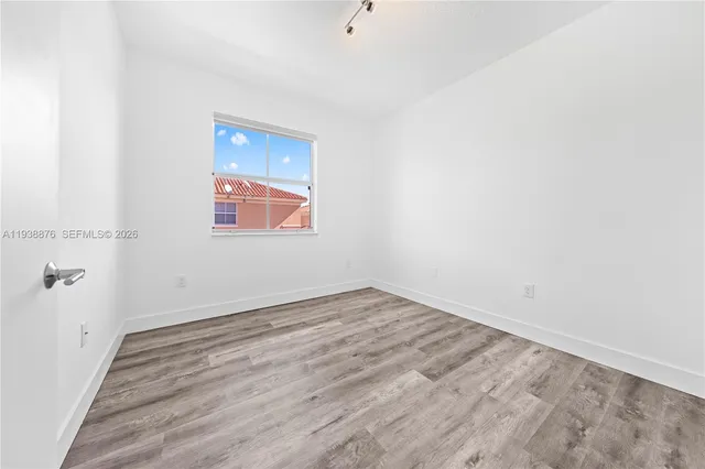 a view of an empty room with wooden floor