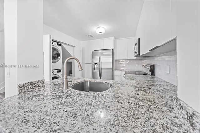 a kitchen with kitchen island a sink stove and refrigerator