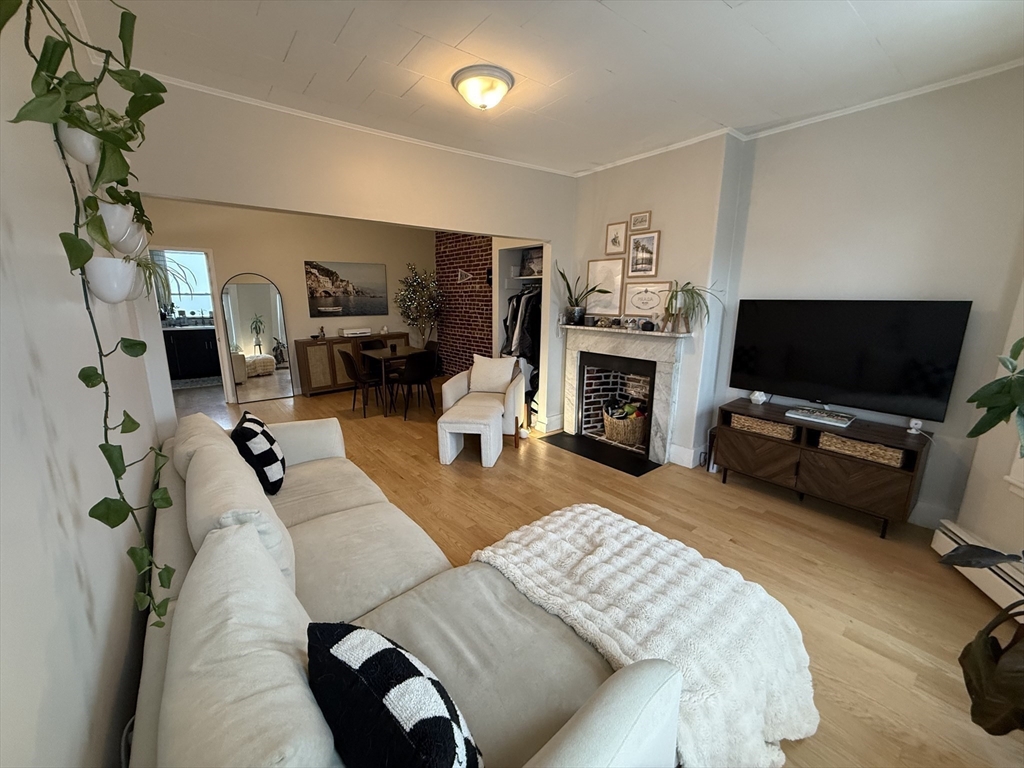 179 Webster Street, Unit 3 Boston, MA 02128 - Photo 2 of 13 a living room with furniture a flat screen tv and a fireplace