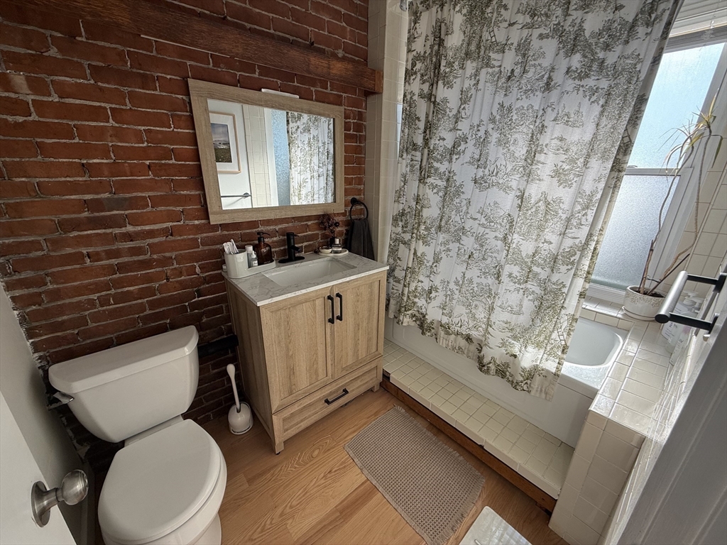 179 Webster Street, Unit 3 Boston, MA 02128 - Photo 10 of 13 a bathroom with a toilet sink and mirror