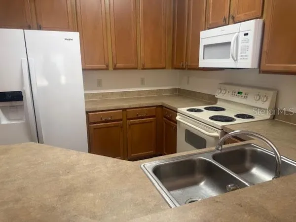 a kitchen with a refrigerator sink and cabinets