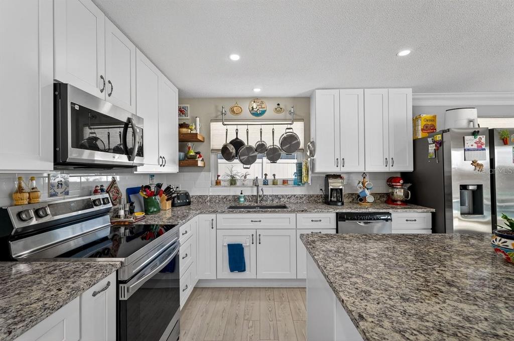 119 Carriage Ponce Inlet, FL 32127 - Photo 12 of 67 a kitchen with stainless steel appliances granite countertop a stove top oven a sink dishwasher and a refrigerator with wooden floor