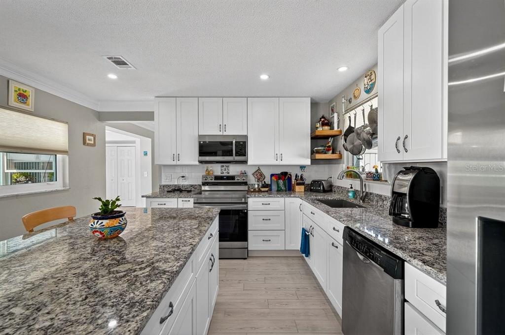 119 Carriage Ponce Inlet, FL 32127 - Photo 14 of 67 a large kitchen with stainless steel appliances granite countertop a sink stove refrigerator granite countertops and cabinets