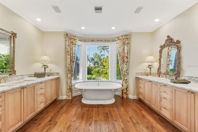 a large spacious bathroom with a double vanity sink a large mirror and a bathtub