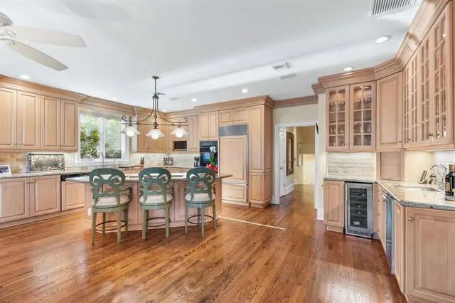 a dining area with stainless steel appliances a dining table chairs and wooden floor