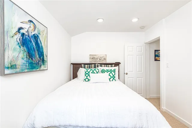 a bedroom with a bed and a painting on the wall