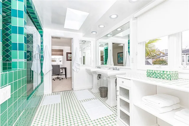 a bathroom with a sink a toilet a mirror and shower
