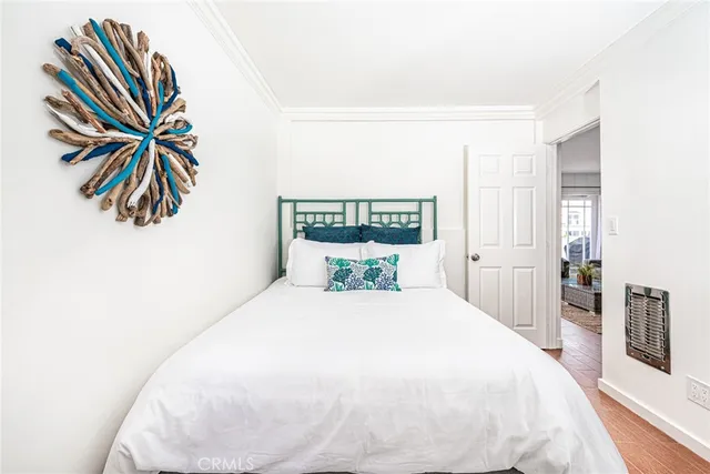 a spacious bedroom with a bed and a painting on the wall
