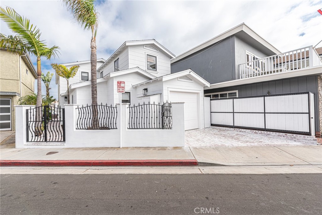 3717 Channel Place Newport Beach, CA 92663 - Photo 23 of 41 a view of a white house with large windows and palm trees