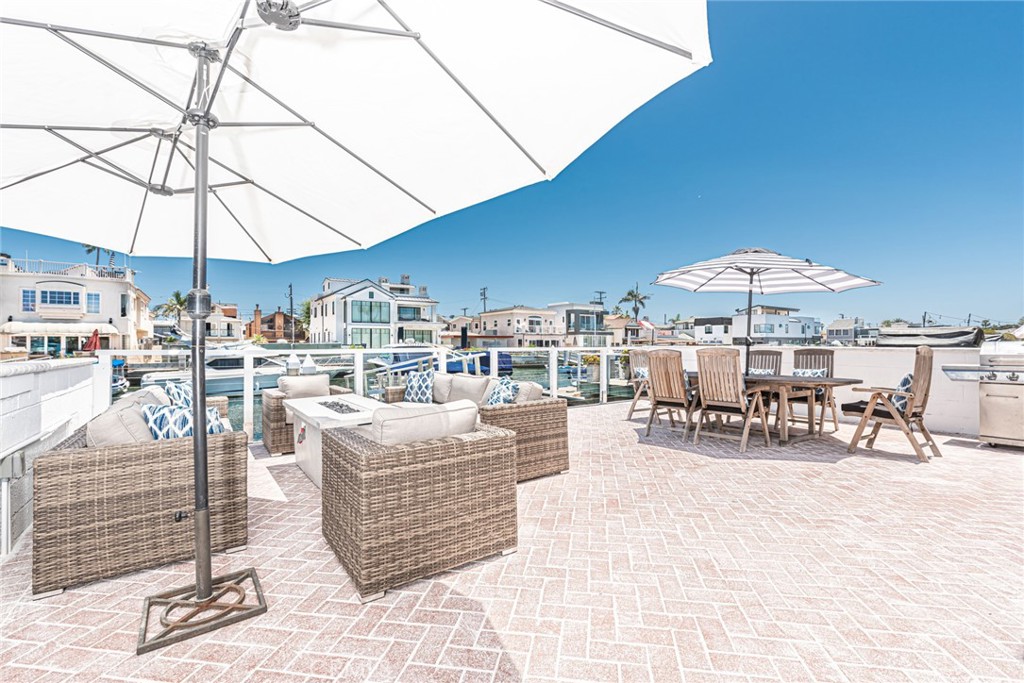 3717 Channel Place Newport Beach, CA 92663 - Photo 7 of 41 a view of a patio with dining table and chairs under an umbrella