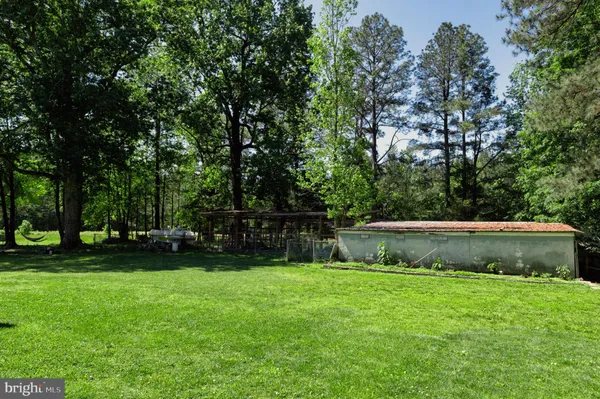 an aerial view of residential house with outdoor space and trees all around