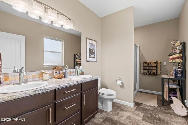 a spacious bathroom with a granite countertop toilet sink and mirror