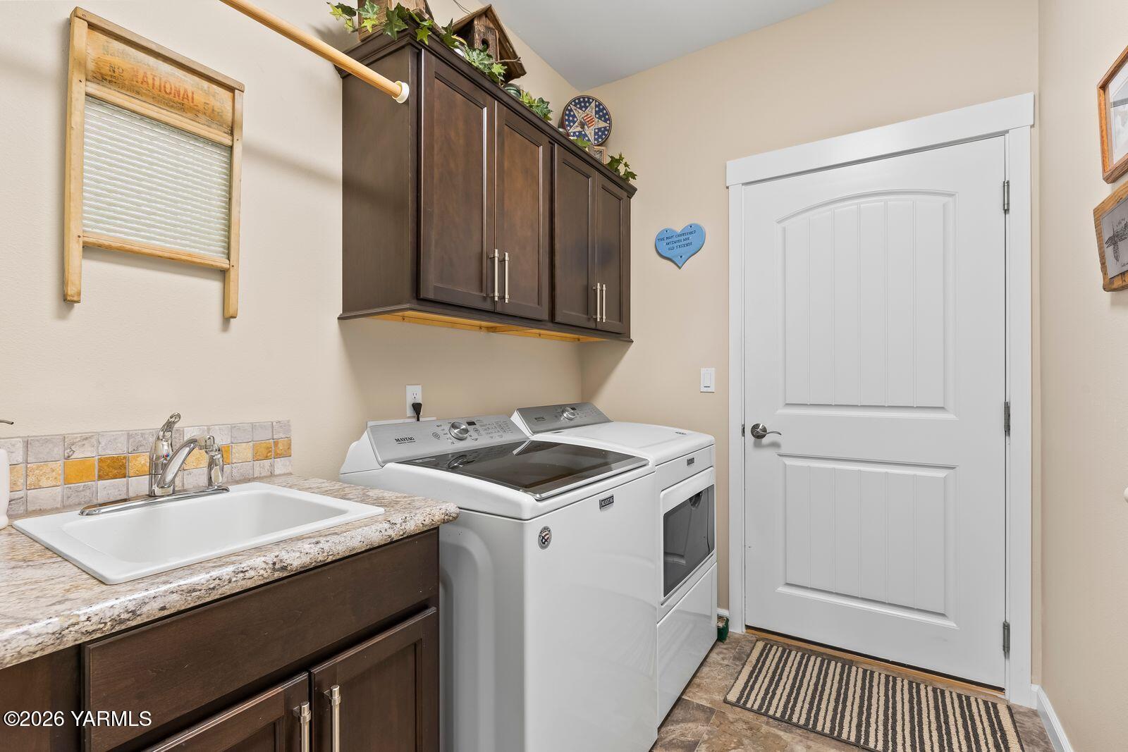 801 Lancaster Road Selah, WA 98942 - Photo 15 of 20 a utility room with cabinets washer and dryer