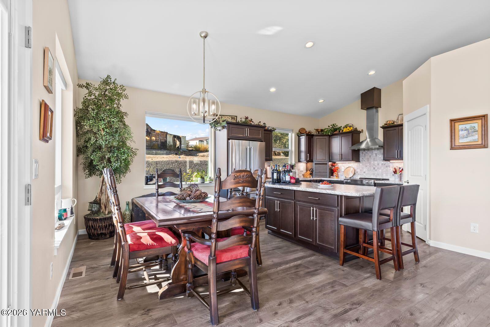 801 Lancaster Road Selah, WA 98942 - Photo 8 of 20 a view of a dining room and livingroom with furniture wooden floor a rug a painting and a chandelier