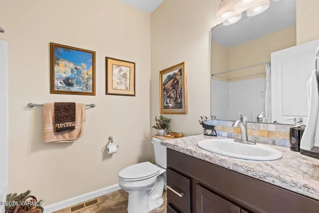 a bathroom with a granite countertop sink mirror and toilet