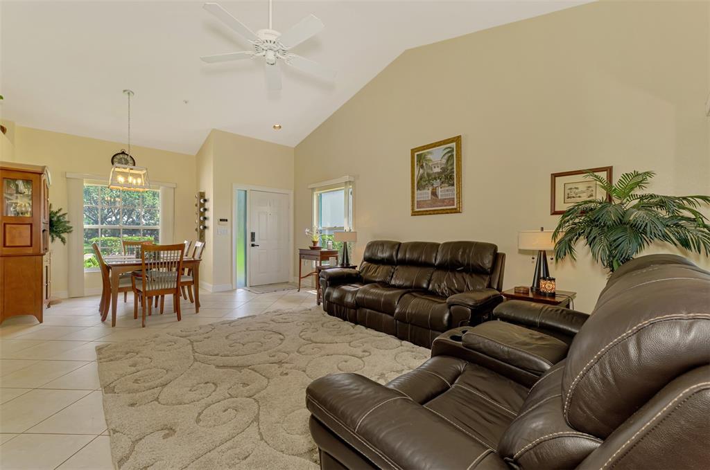 6546 Fairway Gardens Drive, Unit 6546 Bradenton, FL 34203 - Photo 9 of 70 a living room with furniture and a dining table with kitchen view