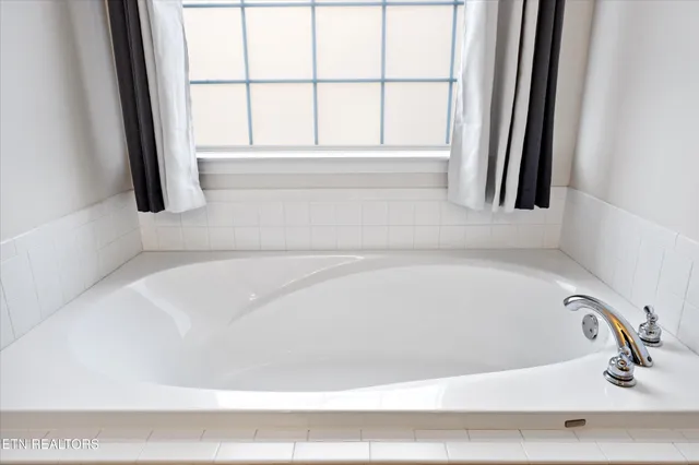 a bathroom with a tub shower vanity and a sink