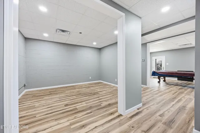 a spacious bedroom with a bed and wooden floor
