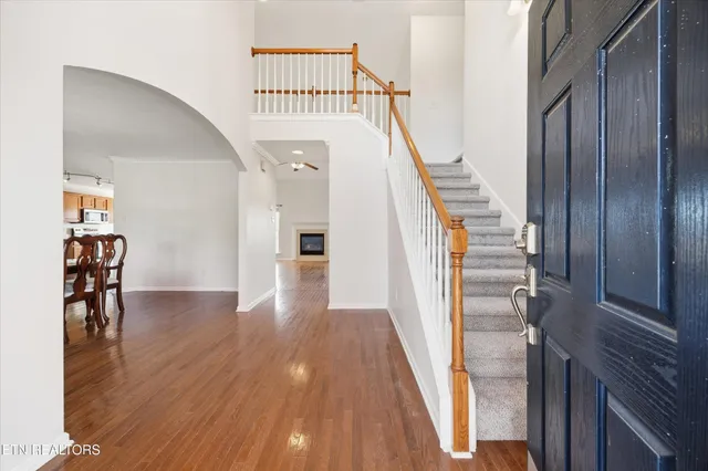 a view of a hallway with wooden floor and staircase