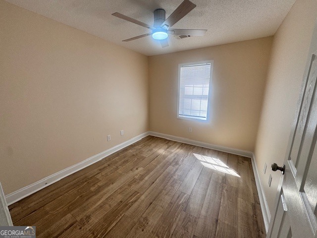 156 Torrance Road Southwest Milledgeville, GA 31061 - Photo 10 of 16 an empty room with wooden floor and windows