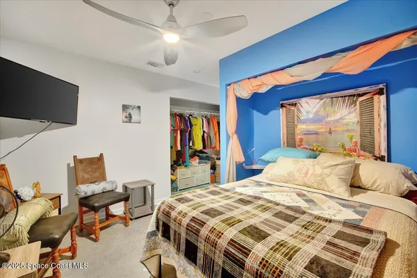 a bedroom with a bed dresser and a flat screen tv