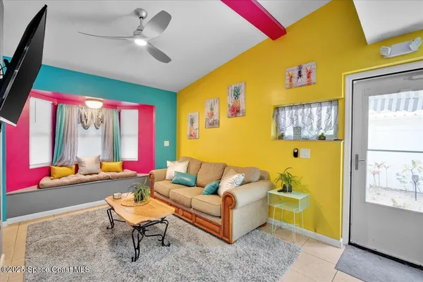 a living room with furniture a flat screen tv and a floor to ceiling window