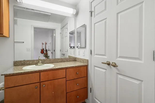 a bathroom with a granite countertop sink and a mirror