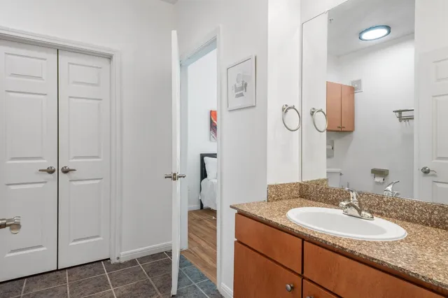a bathroom with a granite countertop sink and a mirror