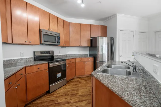 a kitchen with granite countertop stainless steel appliances cabinets a sink and a counter space