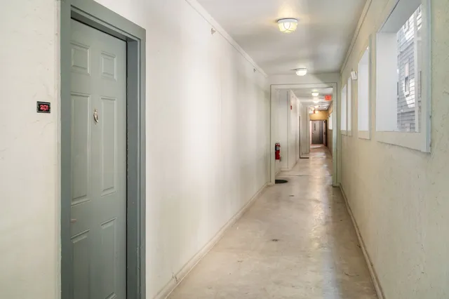 a hallway with wooden floor windows and closet