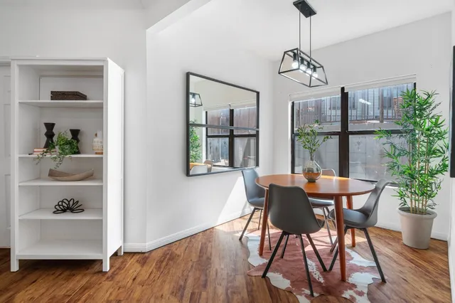 a dining room with furniture potted plants and wooden floor