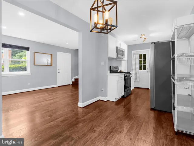 a view of a kitchen with a fridge wooden floor and a window