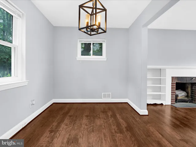 a view of empty room with wooden floor and fireplace