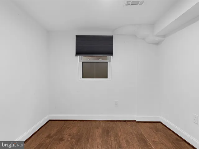 a view of a livingroom with wooden floor and a flat screen tv