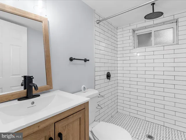 a bathroom with a sink a toilet and mirror