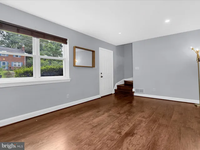 a view of a livingroom with wooden floor and a window
