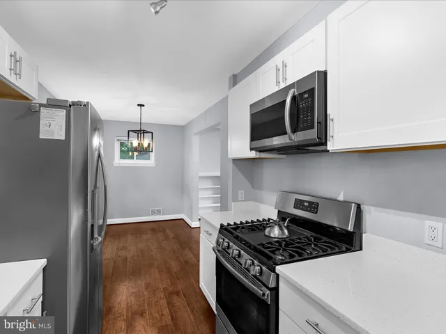 a kitchen with stainless steel appliances granite countertop a stove and a microwave